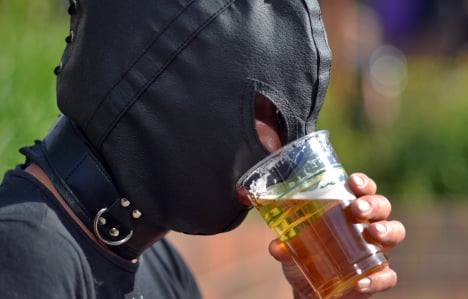 A typical punter struggling to get that first pint refreshment through his gimp mask. Photo: DPA