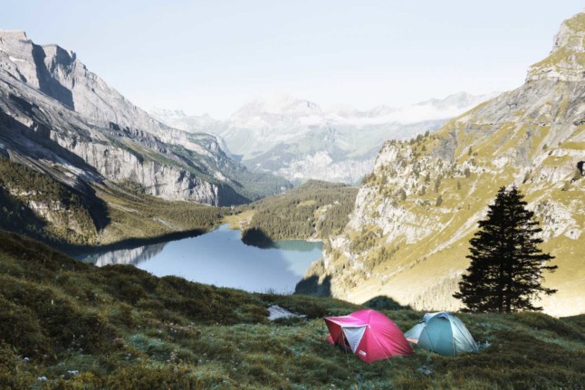 People camping overlooking Oeschinen Lake, in Kandersteg, Switzerland.