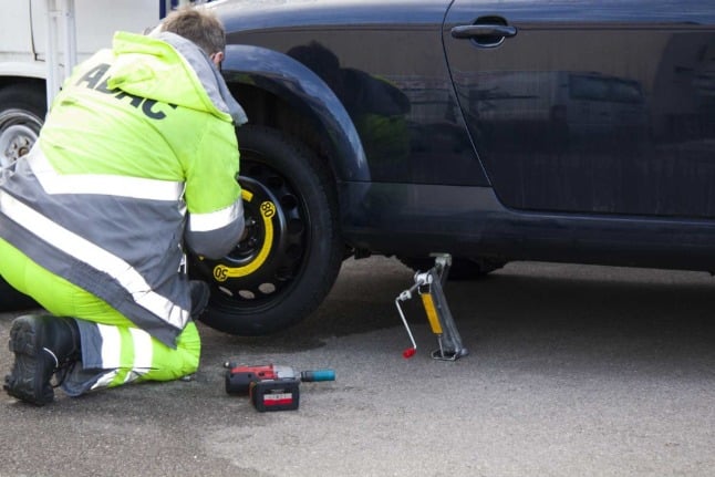 A mechanic from Germany's ADAC repairs a car with flat tyre