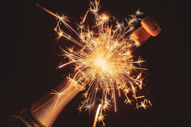 A champagne cork popping, surrounded by sparks