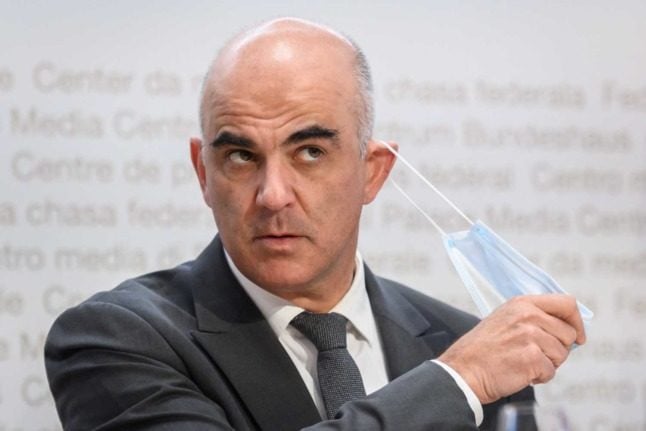 Swiss Health Minister Alain Berset takes off his mask to speak