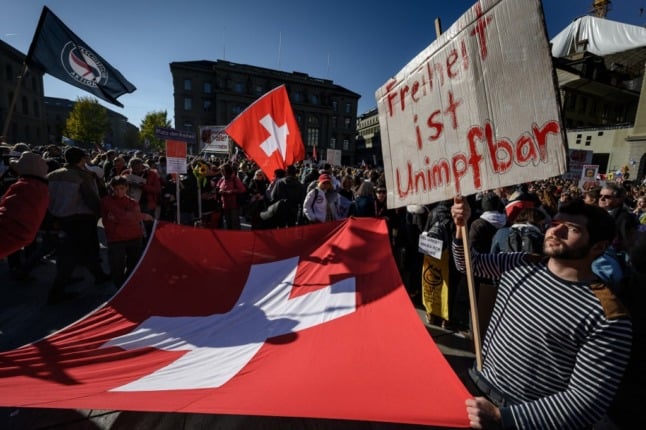 A protester holds up a banner reading in German 'freedom is unvaccinable' during a rally in Bern. Some vaccine opponents pose a threat to Switzerland’s security, experts say. Photo by Fabrice Coffrini / AFP