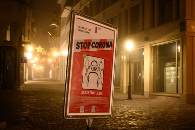 Given the skyrocketing number of infections, this Swiss poster may be just wishful thinking. Photo by: Fabrice COFFRINI / AFP